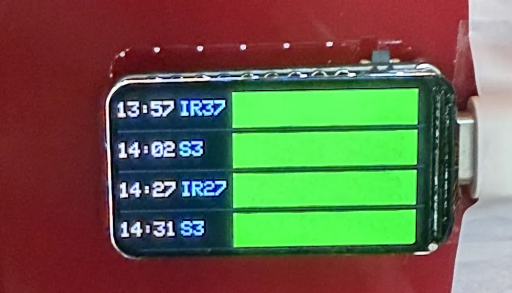 The physical ESP32 departure display, showing Swiss train services on its small screen.